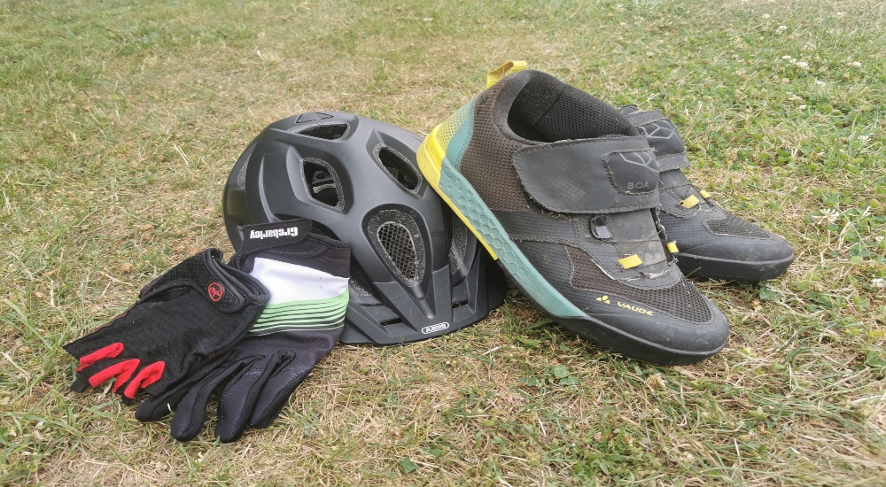 Ausrüstung für das Mountainbike bestehend aus Schuhen, Handschuhen und Helm